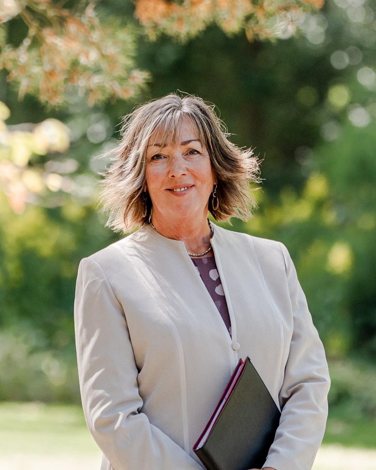 Portrait of celebrant Veronica Hale beneath a golden-leaved tree